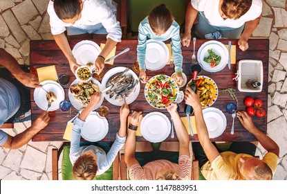 Big Family Have A Dinner With Fresh Cooked Meal On Open Garden Terrace