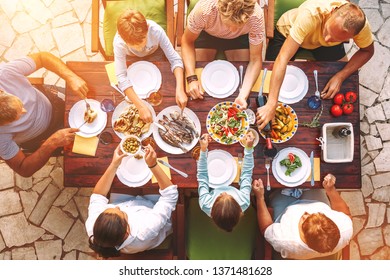 Big Family Have A Dinner With Fresh Cooked Meal On Open Garden Terrace