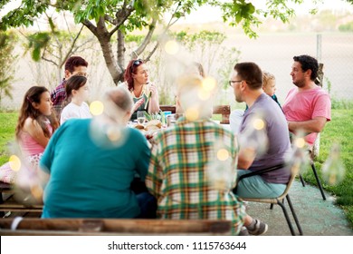 Big Family Having A Meal Outside At The Table Near The Farm On A Chatting And Having Fun.