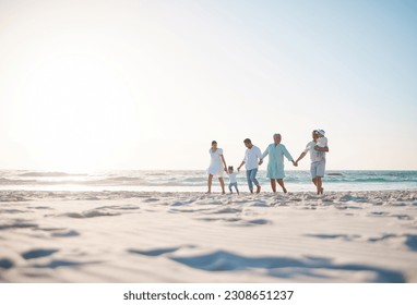 Big family, holding hands and holiday on beach with mockup space for weekend or vacation. Grandparents, parents and kids walking together on the ocean coast for fun bonding or quality time in nature - Powered by Shutterstock