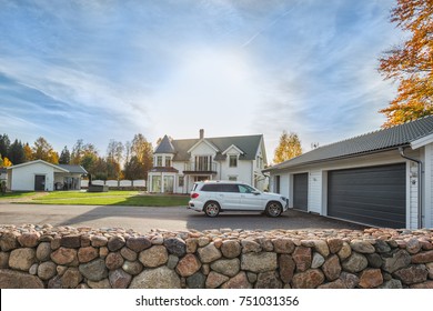 Big family house with double size garage and car parked in front. Residential house with concrete driveway and entrance door under the porch