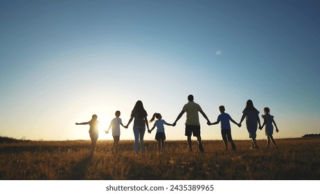 big family. huge community family holding hands walking in the park sunset. happy family kid dream concept. big family community walking with children in sunlight the park. friendly people walking - Powered by Shutterstock