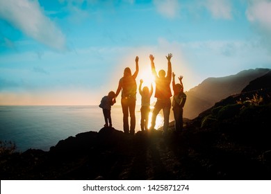 große Familie mit Kindern reist bei Sonnenuntergang in Berge