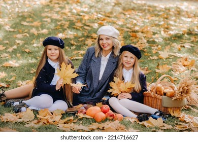 A Big Family On A Picnic In The Fall In A Nature Park. Happy People In The Autumn Park.