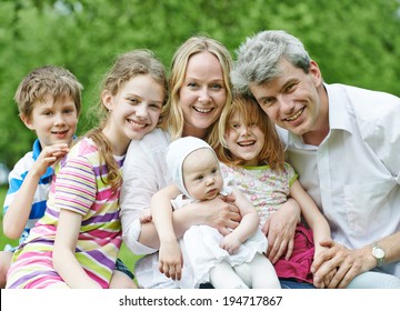 Big Family. Parents With Four Children In Countryside Outdoors