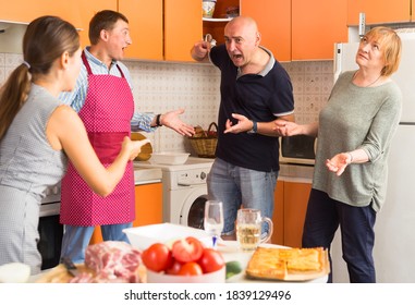 Big Family Quarrel. Two Women And Two Men Quarreling In Home Kitchen..