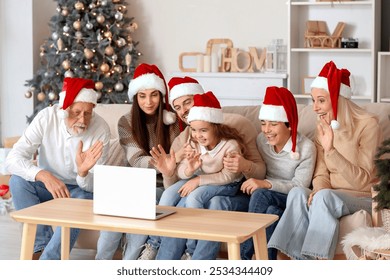 Big family in Santa hats video chatting at home on Christmas eve - Powered by Shutterstock