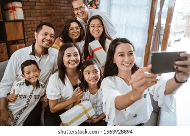 Big Family Selfie On Christmas Day. Asian People Take Picture Using Mobile Phone