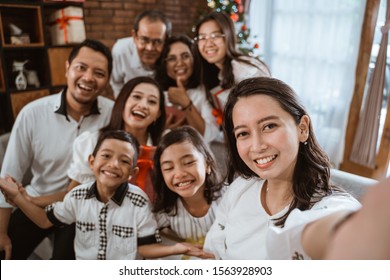 Big Family Selfie On Christmas Day. Asian People Take Picture Using Mobile Phone