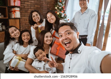 Big Family Selfie On Christmas Day. Asian People Take Picture Using Mobile Phone