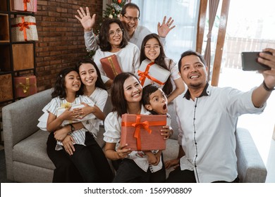 Big Family Selfie On Christmas Day. Asian People Take Picture Using Mobile Phone