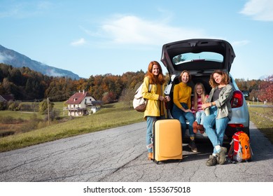 Big Family Trip - Happy Girls Travel By Car. Mamma With Daughters Sitting In The Boot
