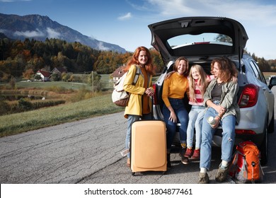 Big Family Trip - Happy Girls Travel By Car. Mamma With Daughters Sitting In The Boot
