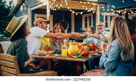 Big Family Vegetarian Party Gathered Together at a Table with Relatives and Friends. Young and Senior People are Eating Vegan Food, Drinking, Passing Dishes, Joking and Having Fun. - Powered by Shutterstock