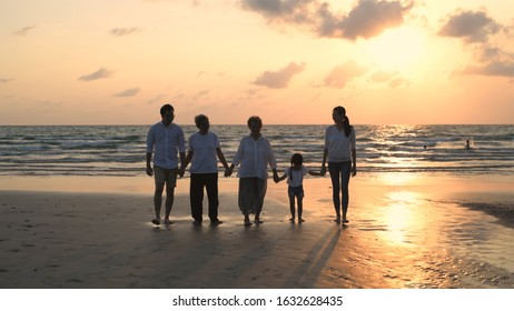Big family walking hand in hand on the beach.