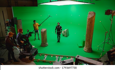 In the Big Film Studio Professional Crew Shooting Blockbuster Movie. Director Commands Cameraman to Start shooting Green Screen CGI Scene with Actor Wearing Motion Capture Suit and Head Rig - Shutterstock ID 1793697730