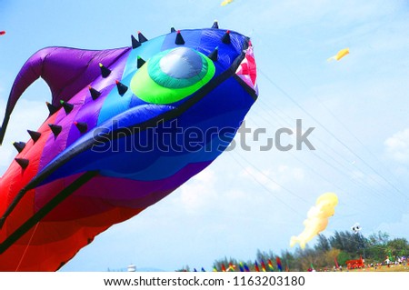 Big Flying Rainbow fish Kite on blue back ground,air kites festival in Hua Hin beach,thailand,amazing kite