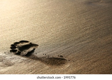 Big Footprint On Golden Sand At Sunset