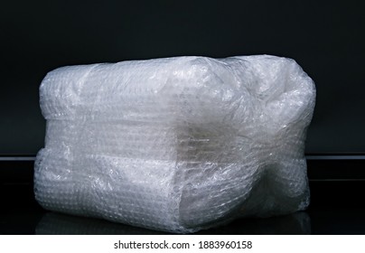 Big Fragile Items Wrapped With Plastic Air Bubble Wrapped And Adhesive Tape On Black Table , Ready To Put Into Parcel Box.