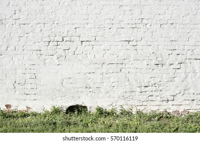 Big Fragment Of White Brick Wall With Grass Stripe Below