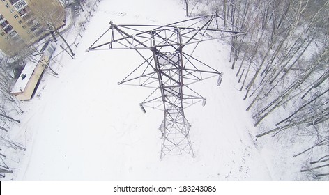 Big Frosty Power Lines Among Winter Snowy Park Near Building. Aerial View