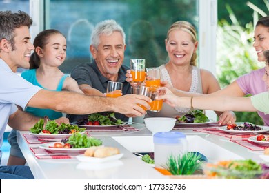 Big Generation Family, Parents, Children And Grandparents, Drink Orange Juice Toast Happy Smile Lunch Dinner At Table, Home