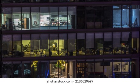 Big Glowing Windows In Modern Office Buildings Timelapse At Night, In Rows Of Windows Light Shines. People Working At Computers Inside