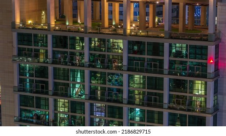 Big Glowing Windows In Modern Office And Residential Buildings Timelapse At Night, In Rows Of Windows Light Shines. Rooftop Playground