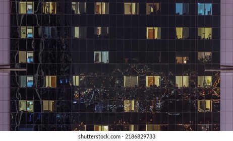 Big Glowing Windows In Modern Office And Residential Buildings Timelapse At Night, In Rows Of Windows Light Shines.