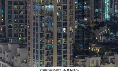 Big Glowing Windows In Modern Residential Buildings Timelapse At Night, In Rows Of Windows Light Shines. Rooftop Garden