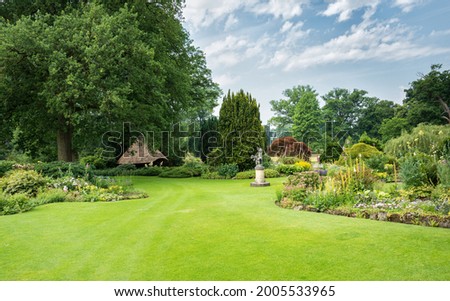 big green gardenwith ngreen grass flowers and gardenhouse