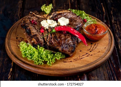 A Big Grilled Steak On A Wooden Plate