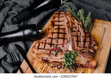 A Big Grilled Steak On A Wooden Plate