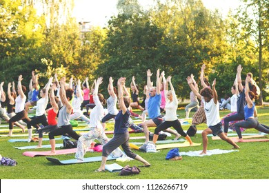 Big Group Of Adults Attending A Yoga Class Outside In Park