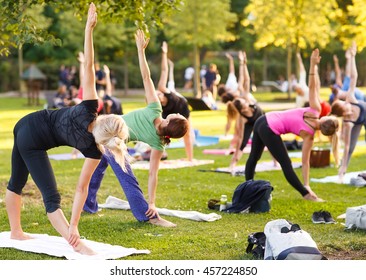 Big Group Of Adults Attending A Yoga Class Outside In Park