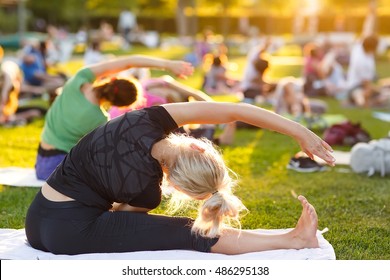 Big Group Of Adults Attending A Yoga Class Outside In Park