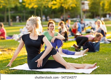 Big Group Of Adults Attending A Yoga Class Outside In Park