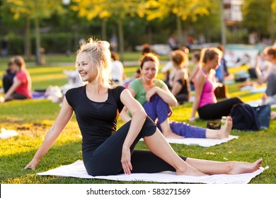 Big Group Of Adults Attending A Yoga Class Outside In Park