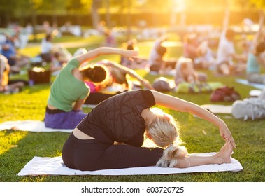 Big Group Of Adults Attending A Yoga Class Outside In Park