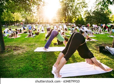 Big Group Of Adults Attending A Yoga Class Outside In Park