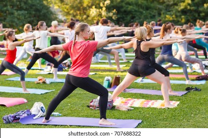 Big Group Of Adults Attending A Yoga Class Outside In Park