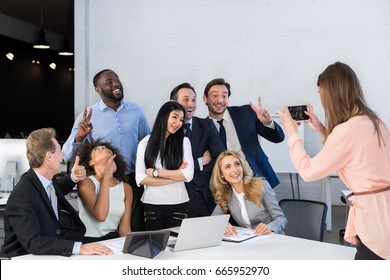 Big Group Of Business People In Office Together, Businesswoman Taking Photo Of Colleagues On Cell Smart Phone, Team Meeting Mix Race Coworkers Businesspeople Happy Smiling Sitting At Desk