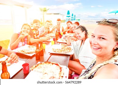 Big Group Of Friends Pizza Party Selfie On Beach Bar Restaurant At Sunset - Happy Teenagers Having Fun On Vacation At Dinner With Drinks And Food On Table - Sun Halo Filter Focus On Right Third Girl