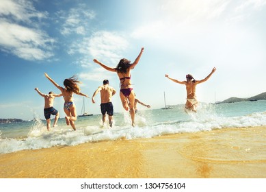 Big Group Of Friends Runs At Sea Beach. Tropical Vacations Concept