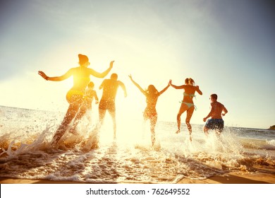 Big group of people having fun at sunset beach - Shutterstock ID 762649552