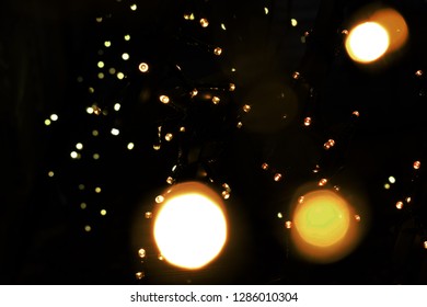 Big group of tiny lights with some bokeh in front and a dark background