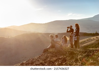 Big group of young peoples are relaxing in sunset mountains
