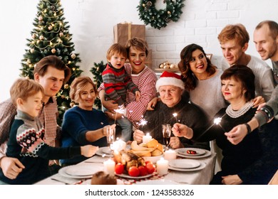 Big Happy Family At The Christmas Table Holding Sparklers