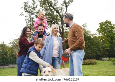 Big Happy Family With Labrador Dog Spending Time Together In Park