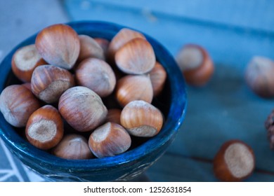 Big hazelnuts in shell in beautiful ceramic blue bowl